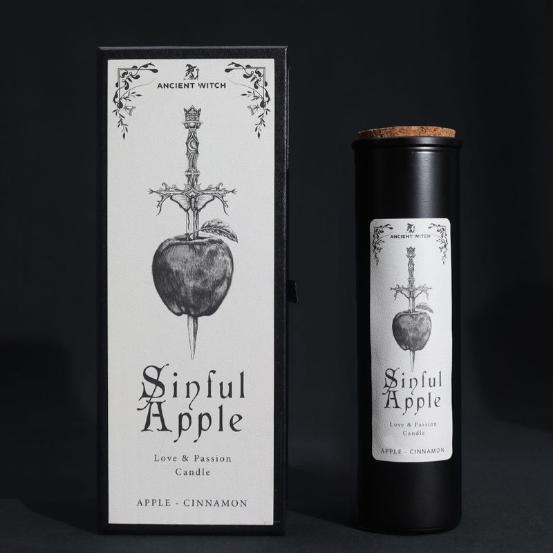Vela ritual de manzana pecadora y caja de regalo de manzana atravesada por un athame sobre un fondo negro